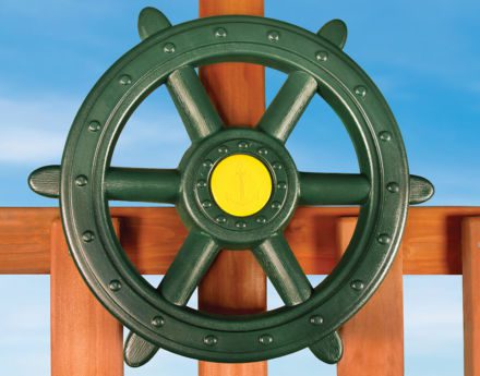 A green ship wheel on a wooden deck.