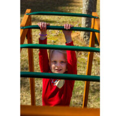 A little girl is climbing on an OUTING SWING SET.