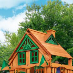 A wooden playhouse with a green roof.