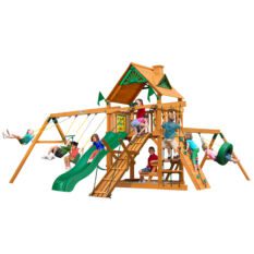 Kids playing on a playhouse with swings, climber, slide, tire swing, and bars