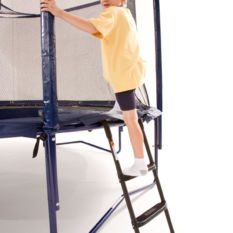A young boy climbing up a Trampoline SureStep Ladders on a trampol.