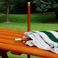 A Children's Picnic Table with Shade Umbrella with a green and white striped umbrella.