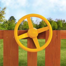 A yellow Steering Wheel on a wooden fence.