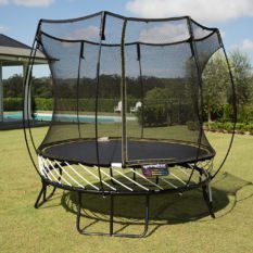 A SpringFree Compact Round Smart Trampoline on a grassy area.