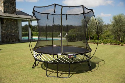 A SpringFree Compact Round Smart Trampoline on a grassy area.