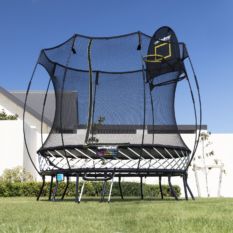 A SpringFree Compact Round Smart Trampoline in front of a house.