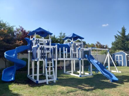A VinylNation Milkyway Climber Swing Set with a slide.