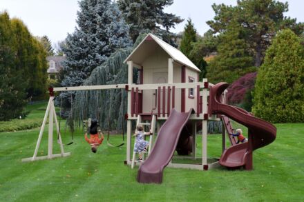 Maroon and white playhouse with slides and swing set 