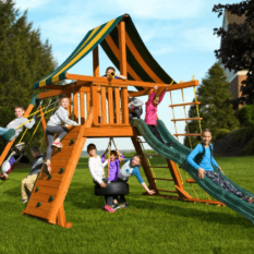 Kids playing on wooden swing set tower with a green slide