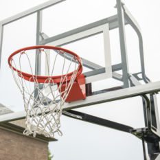 An ALL-AMERICAN basketball hoop in front of a house.