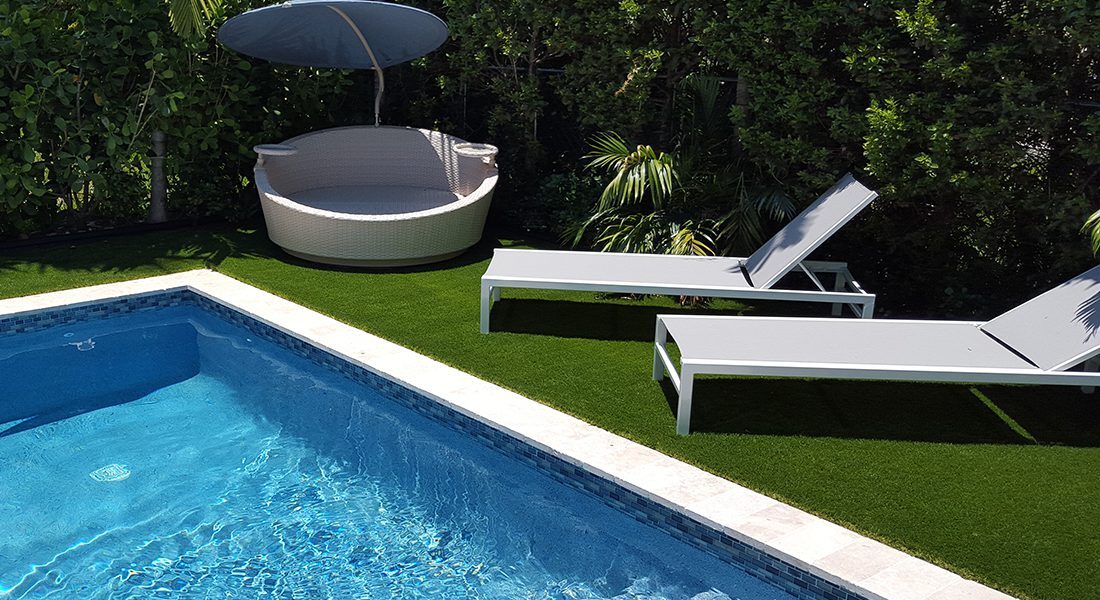 A swimming pool with a lounge chair and umbrella.