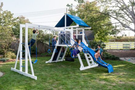 Kids playing on a swing set with a slide