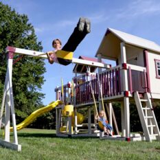 A child is swinging on a VinylNation Galaxy Star Clubhouse.