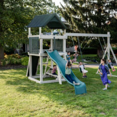 Kids playing on white and blue swing set with a slide